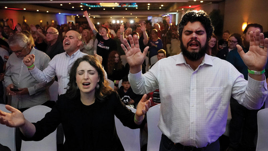 Pond Bank Community Church Pastor Jeremy Lehman and his wife, Sabrina, sing songs of worship during Doug Mastriano’s primary election celebration. — Carolyn Kaster/AP